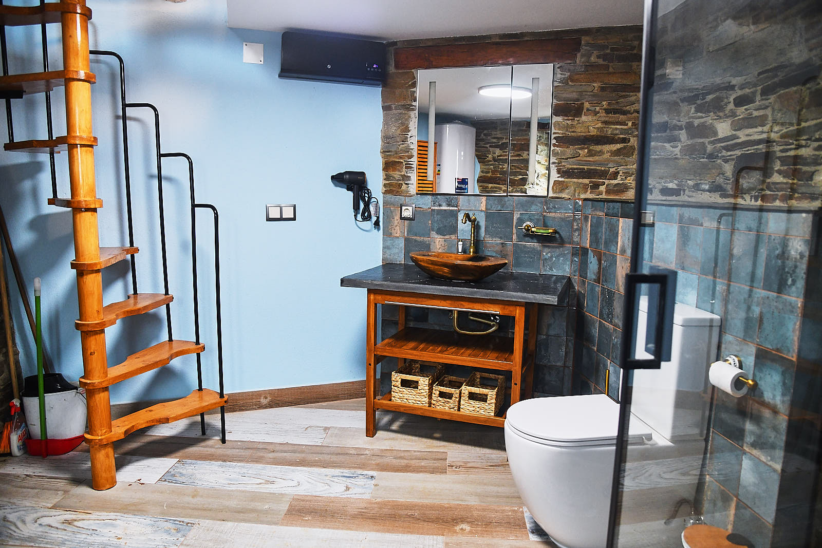 Bathroom with wooden ladder, stone sink and toilet