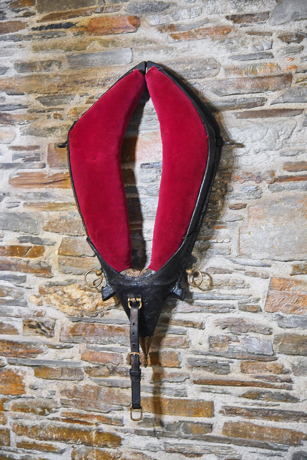 Traditional red bellows displayed on the exposed schist wall